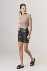 Short de cuero negro con tachas plateadas en cintura y ruedo.