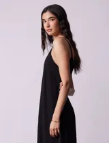 Vestido midi negro de crepe con breteles finos regulables y escote redondo.