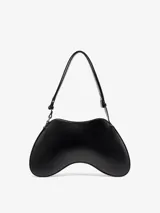 Bolso de hombro negro de cuero con forma sinuosa inspirada en los mandos de videojuegos. Tiene correa ajustable y cierre de cremallera.