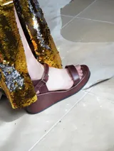 Sandalias de cuero color marrón con plataforma y hebilla ajustable en el tobillo.