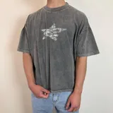 Remera gris con efecto gastado, corte boxy y estampado trasero con logo de la marca Edgy en blanco.