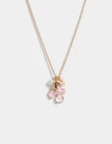Collar de cadena dorada con dije de flor esmaltada en blanco y rosa, con charms de mariposa, perla y cristal.