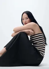 Vestido midi de punto a rayas horizontales negras y crudas, con cuerpo ajustado sin mangas y falda amplia de algodón color negro.