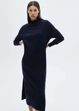 Vestido largo azul marino de tejido de punto fino, corte recto y oversize, con cuello Perkins, mangas largas y aberturas laterales en el bajo.