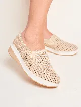 Panchitas color beige con capellada calada, elásticos laterales y suela blanca.