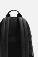 Mochila negra con acabado grabado, compartimento principal con cierre de cremallera, bolsillo interior con cremallera, bolsillo frontal con cremallera, asa de mano, dos asas de hombro ajustables, parte posterior acolchada y banda de sujeción para equipaje.