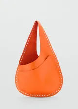 Bolso de hombro color naranja con tachuelas decorativas.