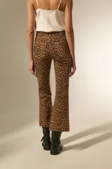 Pantalón de jean estampado camuflado en tonos marrón y beige, de corte flare y tiro alto.