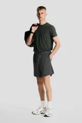 Short deportivo gris de tejido funcional de secado rápido con cintura elástica con cordón ajustable, bolsillos laterales y aberturas laterales en el bajo.