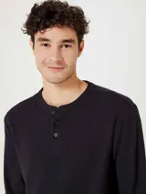 Camiseta beige de manga larga con cuello redondo y tapeta con botones. Tejido texturizado tipo waffle.