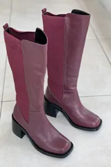 Bota de cuero color burdeos con caña alta y diseño moderno, ideal para temporadas frescas.