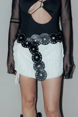 Minifalda blanca de tejido calado con cordones ajustables en los laterales.