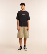 Remera negra de algodón con efecto marmolado, corte oversized, cuello redondo, mangas cortas y estampa frontal con la leyenda "Wild Sea".
