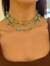 Collar doble capa con bastones de vidrio facetado color ámbar/naranja claro y piedras turquesa irregulares intercaladas. Los herrajes son de acero quirúrgico.