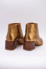 Bota corta plateada de cuero, con punta fina y taco de madera.