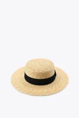 Sombrero de paja natural con ala ancha y cinta negra contrastante alrededor de la base de la copa.