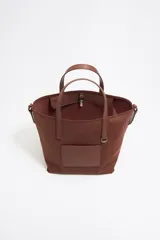 Bolso shopper mediano Bimba y Lola color negro, con doble asa de mano y correa bandolera ajustable y extraíble. Presenta un parche rectangular con el logo de la marca en la parte frontal.