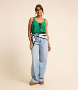 Blusa corta color verde esmeralda, con escote en pico y tirantes medianos con abalorios. Confeccionada en tejido laise texturizado y elástico en la espalda.