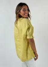 Blusa de lino color amarillo con manga abullonada y escote en V.