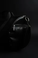 Bolso duffel negro de cuero sintético con logo de ancla bordado en rosa. Tiene doble asa de mano reforzada, correa de hombro regulable y desmontable, cierre superior con doble cremallera y tres bolsillos (dos exteriores y uno interior).