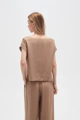 Blusa color marrón claro de viscosa con cuello en V y mangas cortas.