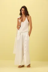 Pantalón palazzo de lino color blanco, con cintura elastizada y botones decorativos en los laterales.