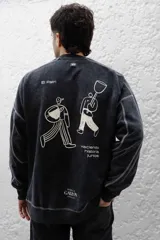 Buzo negro de frisa de algodón con calce oversize y lavado gastado. Tiene costuras a contratono y recortes.