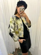Chaqueta corta con mangas 3/4 y estampado abstracto en tonos beige, negro, gris y verde.