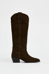 Bota alta de caña alta color marrón chocolate, de serraje con puntera fina y taco bajo.