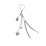 Llavero con dije de guitarra y corazón metálicos, cadenas y cintas en blanco y negro.