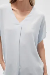 Blusa color beige de lino, holgada y con cuello en V.