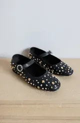 Chatas de cuero plateadas con detalles de tachas, inspiradas en el modelo 'Mary Jane' y diseñadas para ofrecer comodidad y estilo.