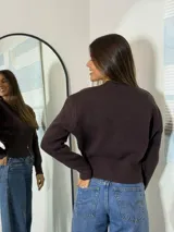 Sweater marrón de punto con cuello redondo y cierre frontal con cremallera.