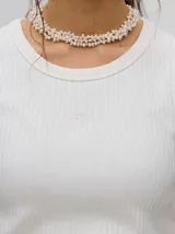 Musculosa crop de algodón, color azul grisáceo, con tejido acanalado (rib) y cuello redondo. Presenta un pequeño logo bordado en el centro del pecho.