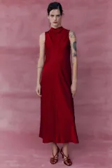 Vestido midi rojo de satén con cuello alto y sisas amplias. Cierre en la espalda con abertura y botones.