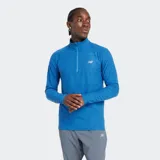 Buzo deportivo New Balance de manga larga, color azul con efecto jaspeado (space dye), cuello alto con cierre de un cuarto y logo reflectante en el pecho.