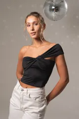 Top negro asimétrico de un solo hombro con drapeado frontal y nudo central, confeccionado en tejido suave y ajustado al cuerpo.