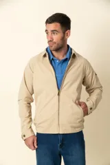 Campera color beige con cierre frontal, cuello camisero, bolsillos laterales y elástico en la cintura. Detalle de bolsillo en la manga izquierda.