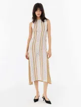 Vestido midi color beige con galones de encaje y puntillas blancas.