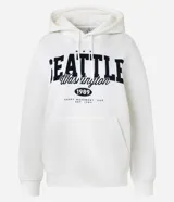 Saco cerrado tipo hoodie blanco con capucha, cordón ajustable, bolsillo canguro y estampa frontal con el texto "SEATTLE Washington 1989".