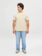 Remera color crema de manga corta con cuello redondo y calce holgado. Estampa en la espalda con el logo de Jack & Jones y un edificio.