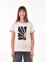 Remera color crudo con estampado abstracto en negro y naranja.