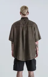 Camisa manga corta color verde militar, de corte amplio y confeccionada en lino.