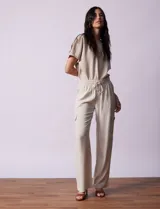 Pantalón cargo de lino color beige, marca Marissa Olivia. Con pretina ancha elastizada, lazo de ajuste, bolsillos inclinados delanteros y bolsillos laterales con botón.