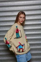 Sweater tejido color crema con diseño de esquiadores en colores.