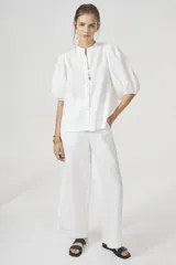 Camisa blanca de lino con cuello mao, mangas globo al codo y botones de nácar.