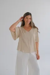 Blusa beige de mangas cortas con volados y escote en V.