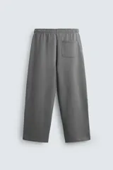 Pantalón jogger wide fit negro confeccionado en tejido de algodón con interior rizo. Pernera ancha, cintura elástica ajustable con cordón interior, bolsillos laterales y bolsillo trasero de plastrón.