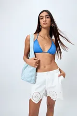 Short blanco de algodón con bordado calado y terminación festoneada en el borde inferior.