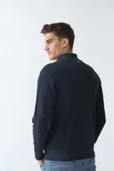 Campera marrón de algodón con cierre frontal, cuello alto, bolsillos laterales, puños y logo bordado en el pecho.